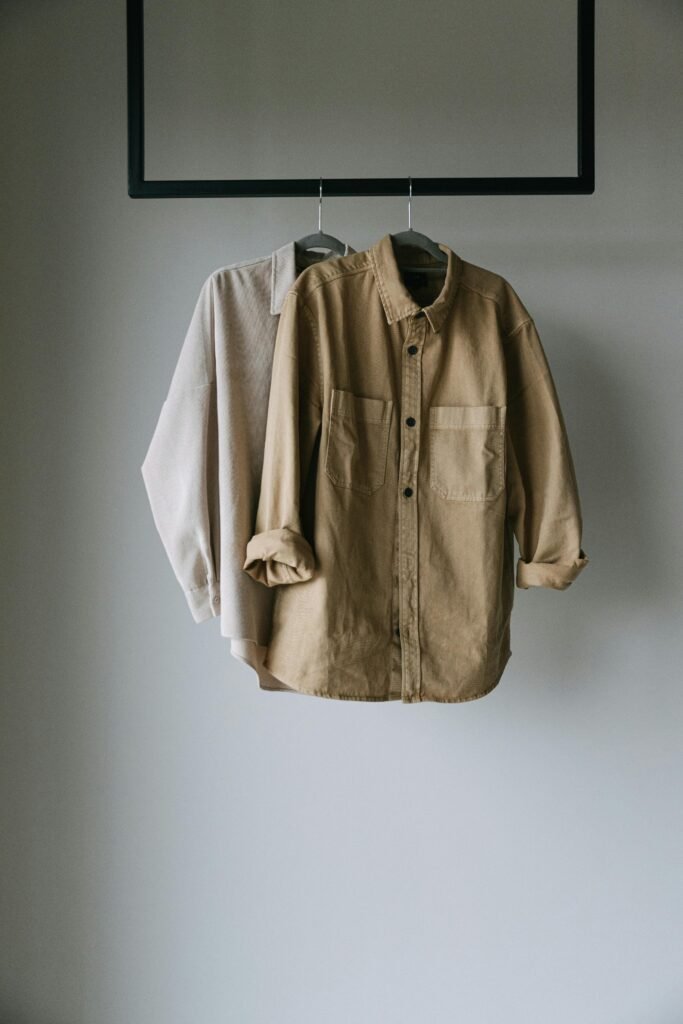 pexels-photo-7671168-7671168 Two neutral shirts hanging on a rack, perfect for minimalist fashion concepts.